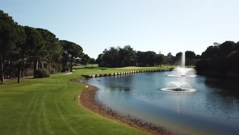 Golfer-strikes-ball-in-man-back-shot-while-drone-follows-it