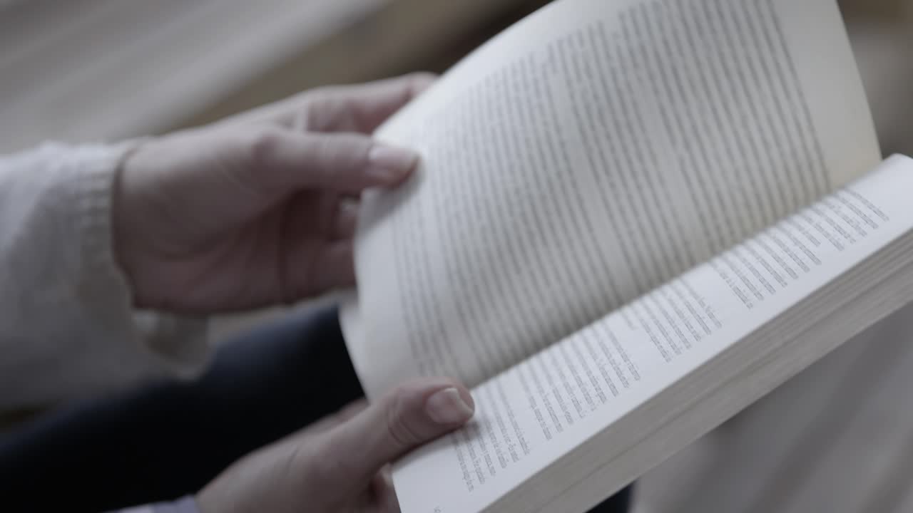 Close-up of Hands Reading a Book and Turning Pages