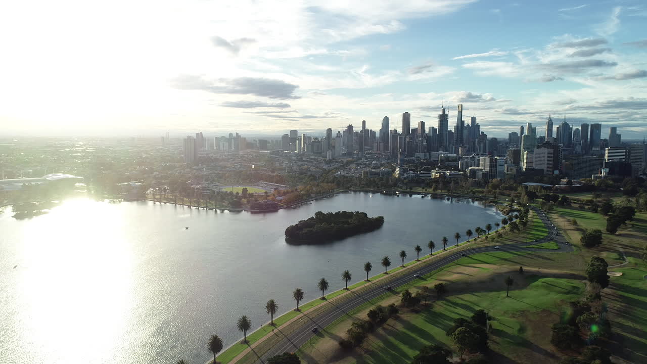 panorámica suave y decente sobre el lago albert park que muestra melbourne cbd bajo una gloriosa luz brillante
