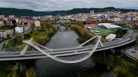 millennium bridge miño river in ourense, galicia, spain with roman bridge behind