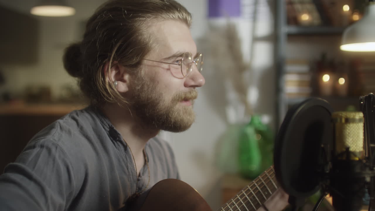 Man Playing Guitar and Singing at Home Recording Studio
