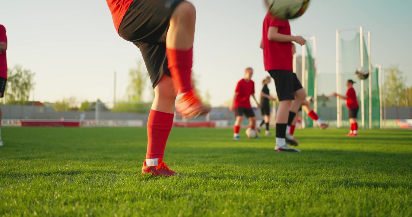 Giovani calciatori che palleggiano su un campo verde durante l'allenamento.