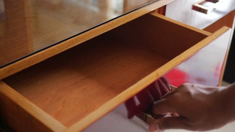 person opening a wooden drawer