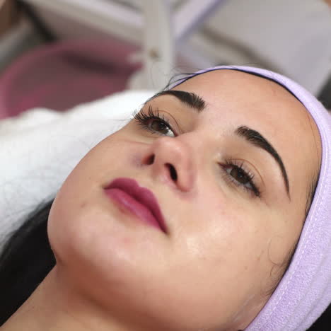 beautiful woman at the spa receiving facial treatment. rejuvenating massage. work of the cosmetologist