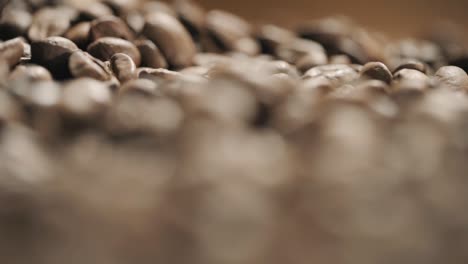 granos de café frescos esparcidos en una mesa de madera a cámara lenta