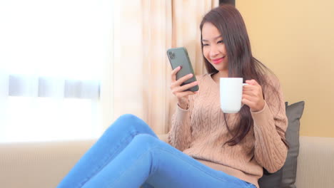 커피 한 잔과 스마트폰은 젊은 여성의 완벽한 아침을 만든다