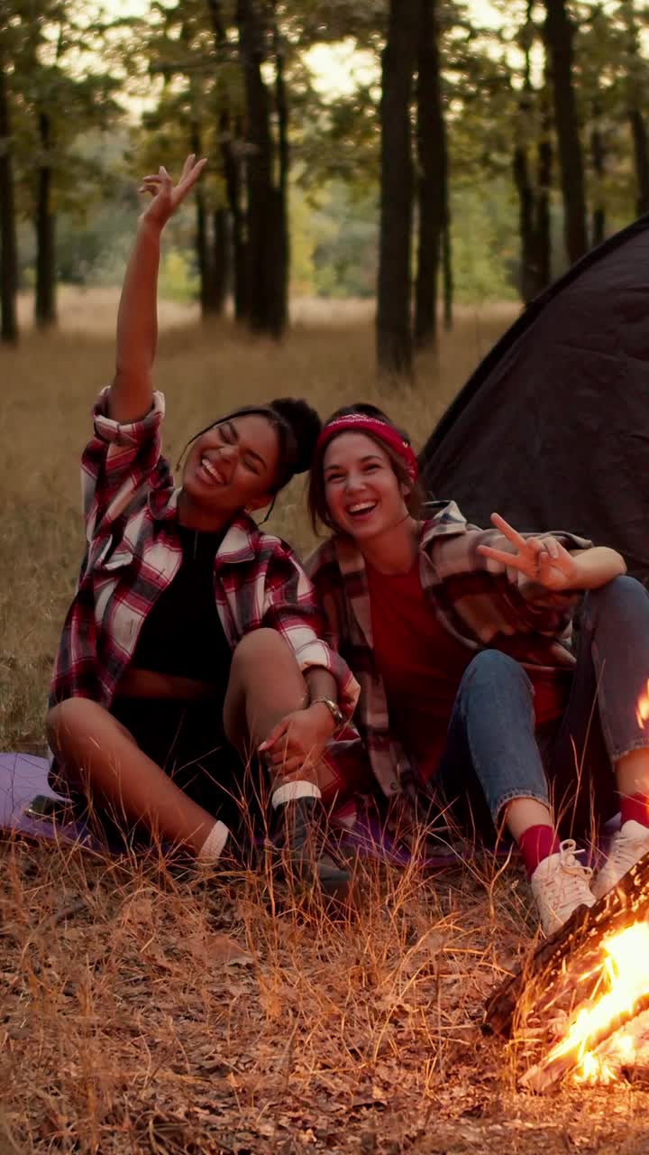 Due donne in campeggio vicino a un falò