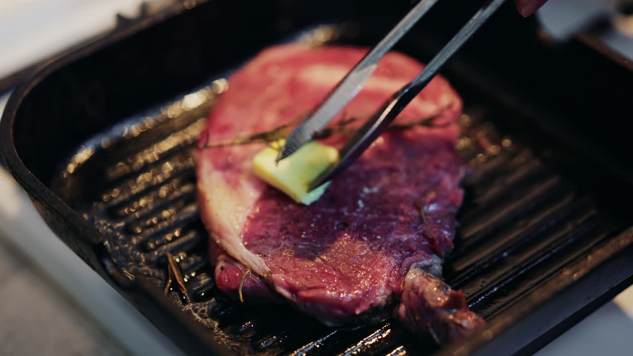 Close up of a juicy steak being moved with a spatula on a hot grill pan