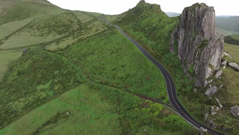 Green-pick-up-truck-drives-on-dirt-road-at-Flores-island,-Azores---Drone-shot