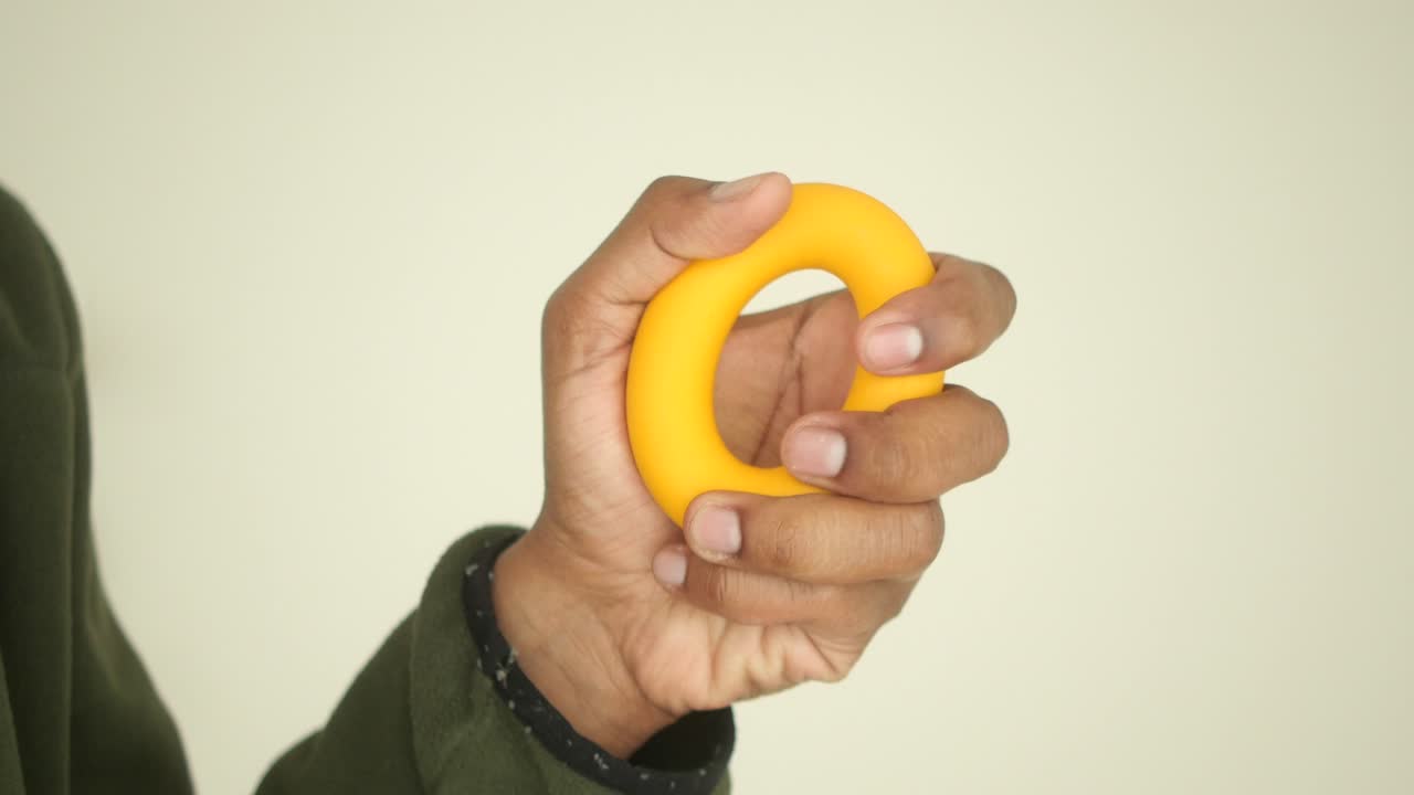 Hand holding a yellow exercise ring