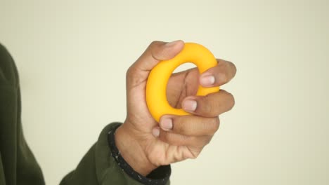 hand holding a yellow exercise ring