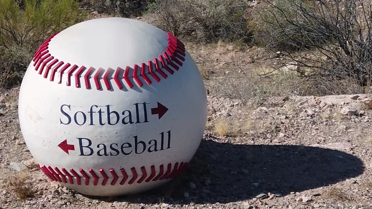 Pan across a huge baseball used as a directional sign to the proper field usage, Papago Park, Papago Sports Complex, Phoenix, Arizona.