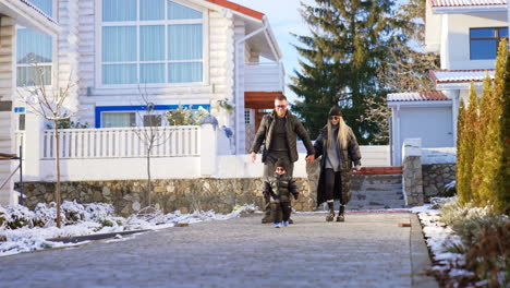 beautiful caucasian couple walks holding hands. their adorable toddler son runs i front of the parents.