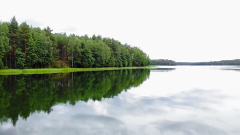 Reflexionen-Im-Ruhigen-Wassersee-Umgeben-Von-Laubwaldlandschaft-Bei-Tageslicht-In-Pradzonka,-Nordpolen