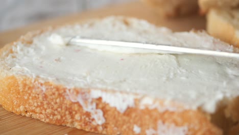 close up of a butter knife spreading butter on bread