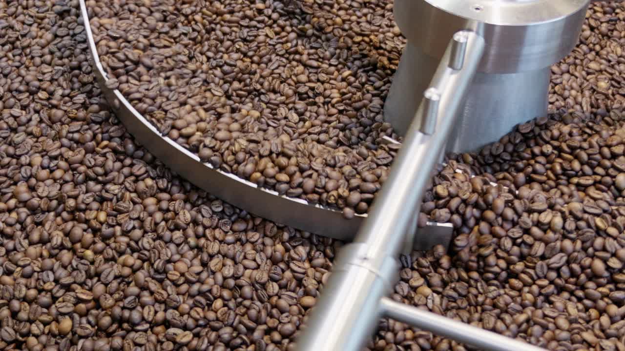 Coffee roasting process in an industrial facility close-up view of roasted beans machinery