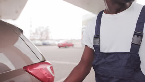 man filling a car with gas at a gas station