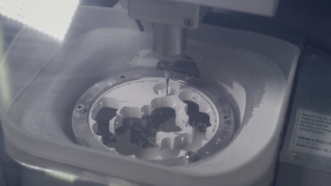 una máquina cnc profesional crea automáticamente una prótesis dental. el taladro muele una imitación de una mandíbula cerámica. tecnología avanzada en odontología. producción de implantes dentales