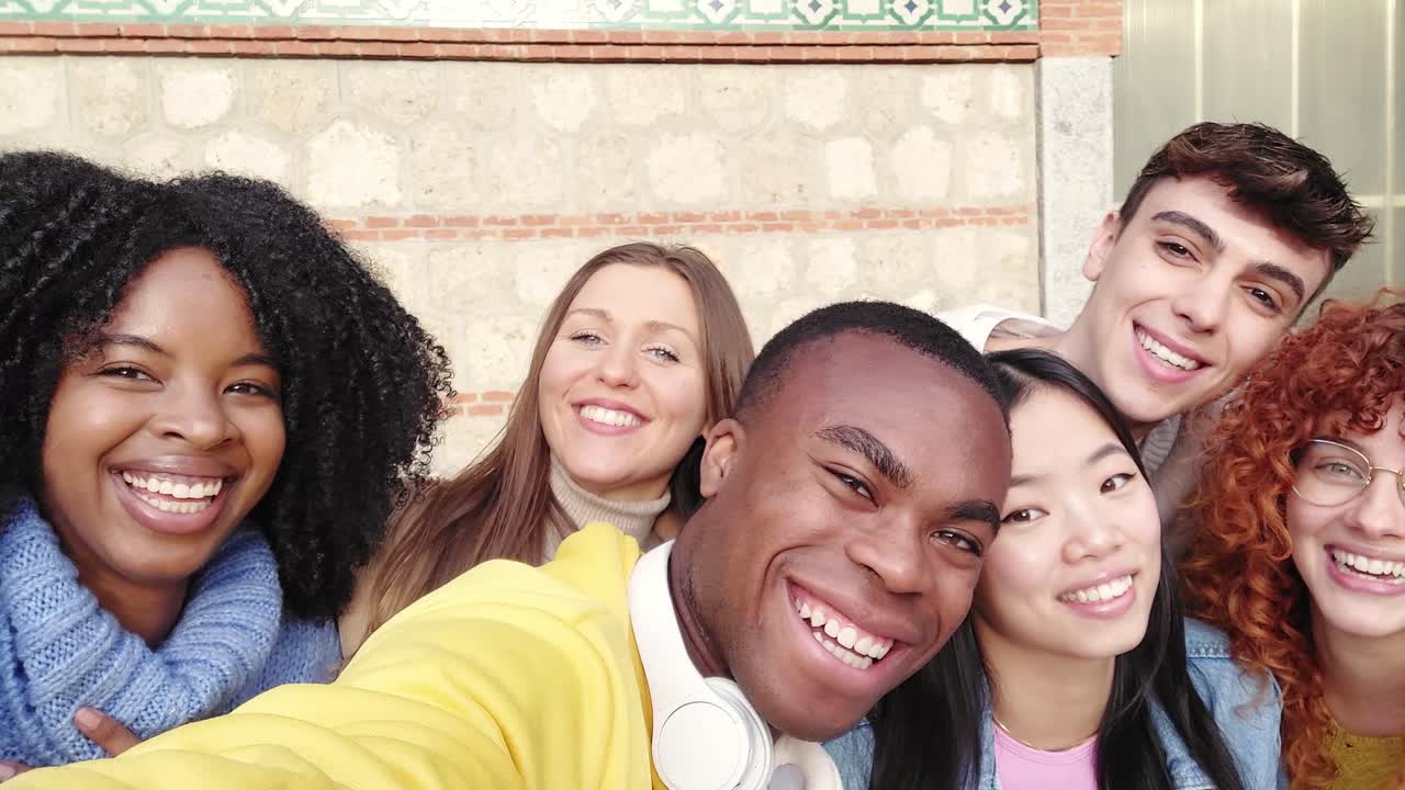 African american young man taking a selfie with friends outdoors