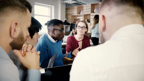 team brainstorming in trendy loft modern office. young multiethnic creative smiling employees business discussion 4k