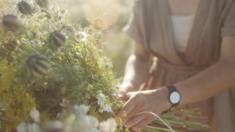 tying a bouquet on a meadow during the summer sun