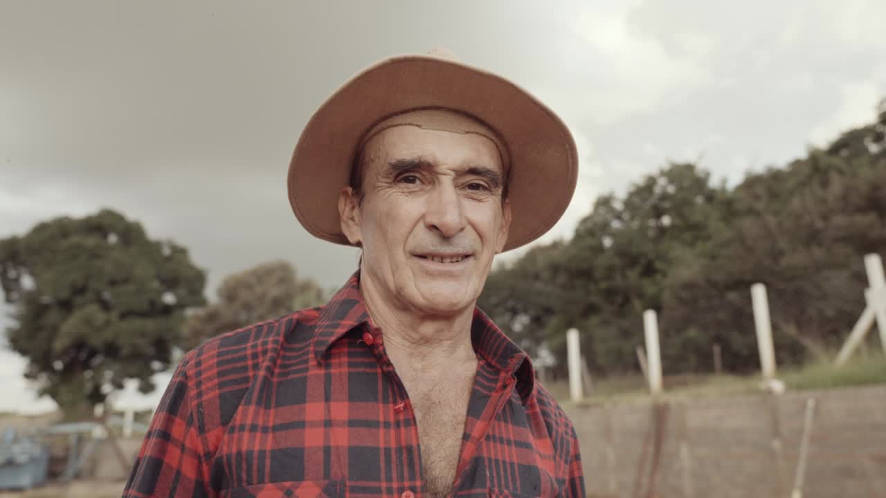 hombre granjero latino en la camisa casual en la granja en el fondo de la granja. cinematográfico 4k