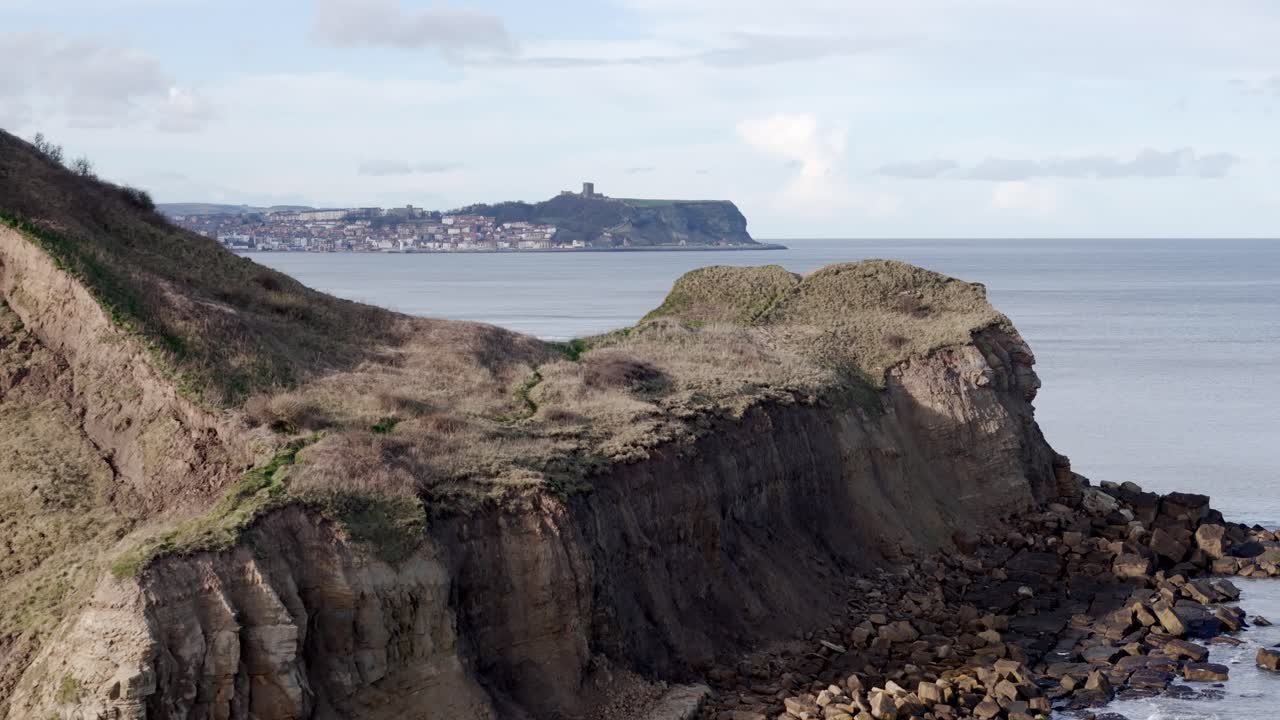 북 요크셔 해안선의 전진 항공 영상과 멀리 있는 스카버러 마을