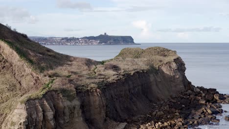 Imágenes-Aéreas-En-Movimiento-Hacia-Adelante-De-La-Costa-De-North-Yorkshire-Con-La-Ciudad-De-Scarborough-En-La-Distancia