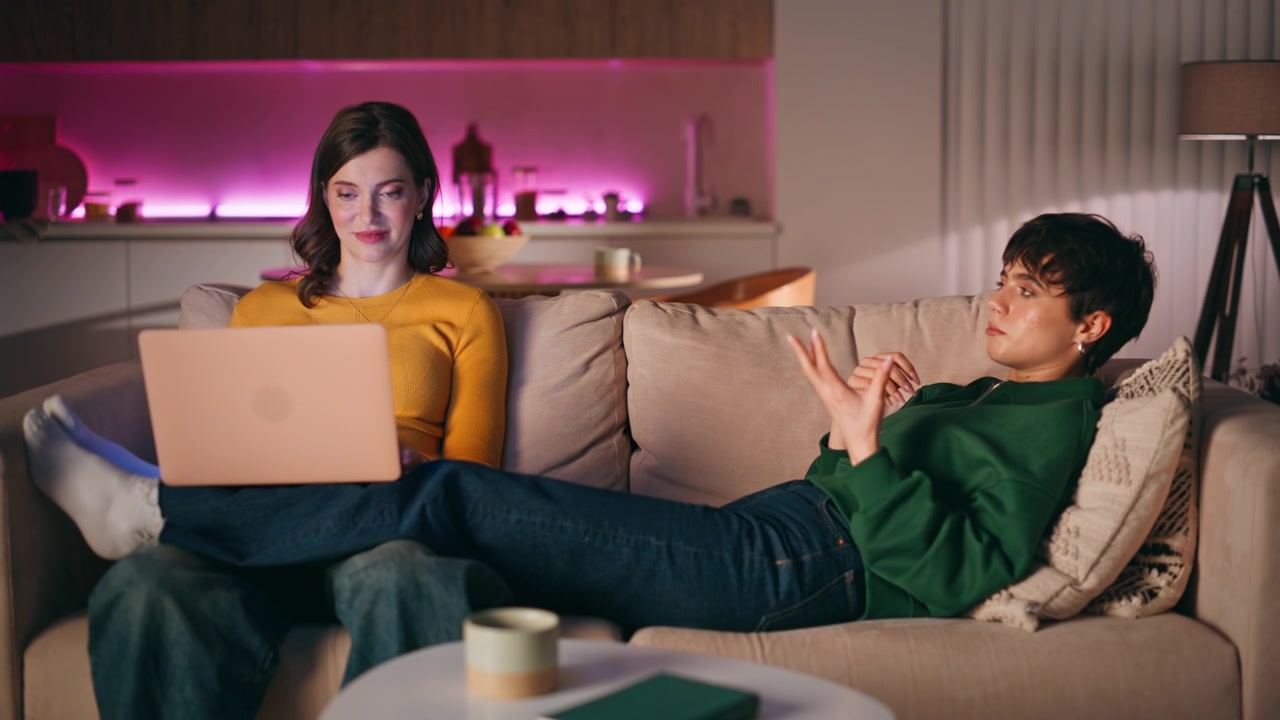Casal lésbico feliz conversando e planejando férias juntos em casa à noite
