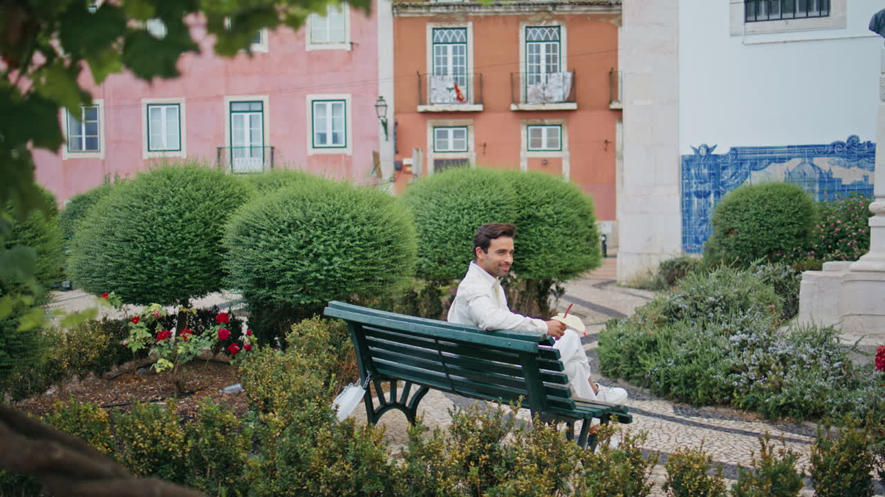 descansando macho sosteniendo una flor sentado en un banco solo. hombre feliz esperando a su novia