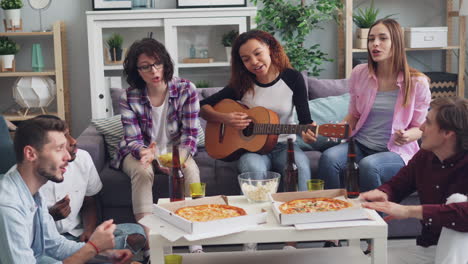 friends enjoying a pizza party with music