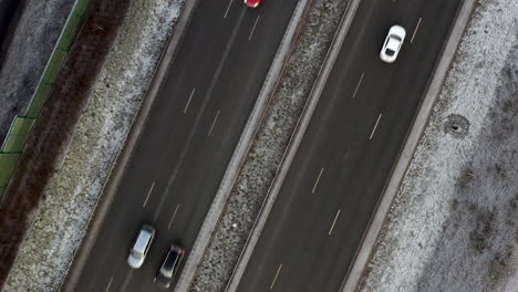 aerial, screwdriver, drone shot, top down above traffic on parallel roads, in helsinki city, on a cloudy winter day, in finland