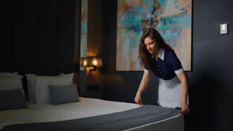 criada de hotel haciendo la cama en una habitación de hotel
