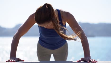 Attractive-sporty-girl-exercising-at-riverside