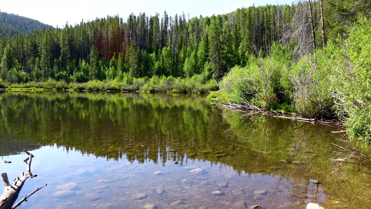 Static video of Rainbow Lake in Breckenridge Colorado. Scene shows a clear lake with a scenic view of nature and trees behind it,