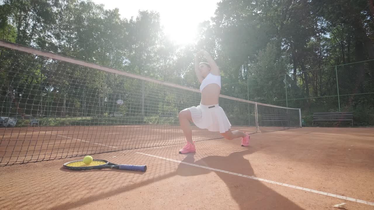 코치와 함께 야외 코트에서 테니스를 연습하는 젊은 여성. 코치는 선수가 그녀의 기술에 대해 일하면서, 운동 훈련 세션에서 그녀의 스트로크를 완성하는 동안 지침을 제공합니다.