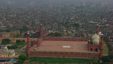 lahore, pakistán, vista aérea de la mezquita patrimonial badshahi con vista a la ciudad, la mezquita más antigua de los emperadores mogoles, cometas negras volando, cuatro minaretes de la mezquita