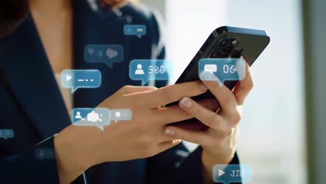 woman's hands using smartphone with social icons