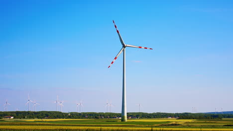wind turbines in a green field landscape. wind turbines stand tall in a vibrant green field under a clear blue sky, showcasing renewable energy production