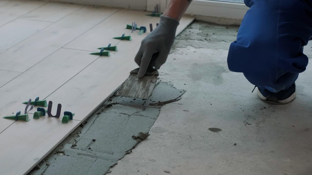 Construction, renovation, repair apartment. Installing ceramic floor tiles - measuring and cutting the pieces. Cuts tile. Tile cutting