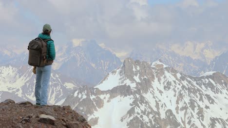 mujer excursionista de pie alcanzando la cima. vista de las montañas nevadas.