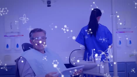 animación de moléculas sobre un paciente masculino en la silla del dentista.
