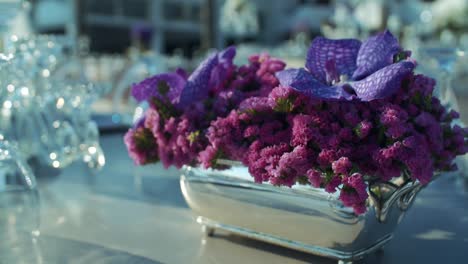 la cámara se acerca a las flores moradas en la gran mesa de comedor