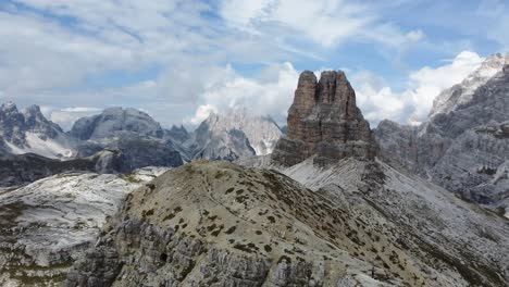 Un-Hombre-Disfrutando-De-La-Vista-Del-Paisaje-De-Los-Dolomitas-En-El-Norte-De-Italia-En-Un-Día-Azul-Claro,-Con-Una-Enorme-Formación-Rocosa-En-El-Fondo