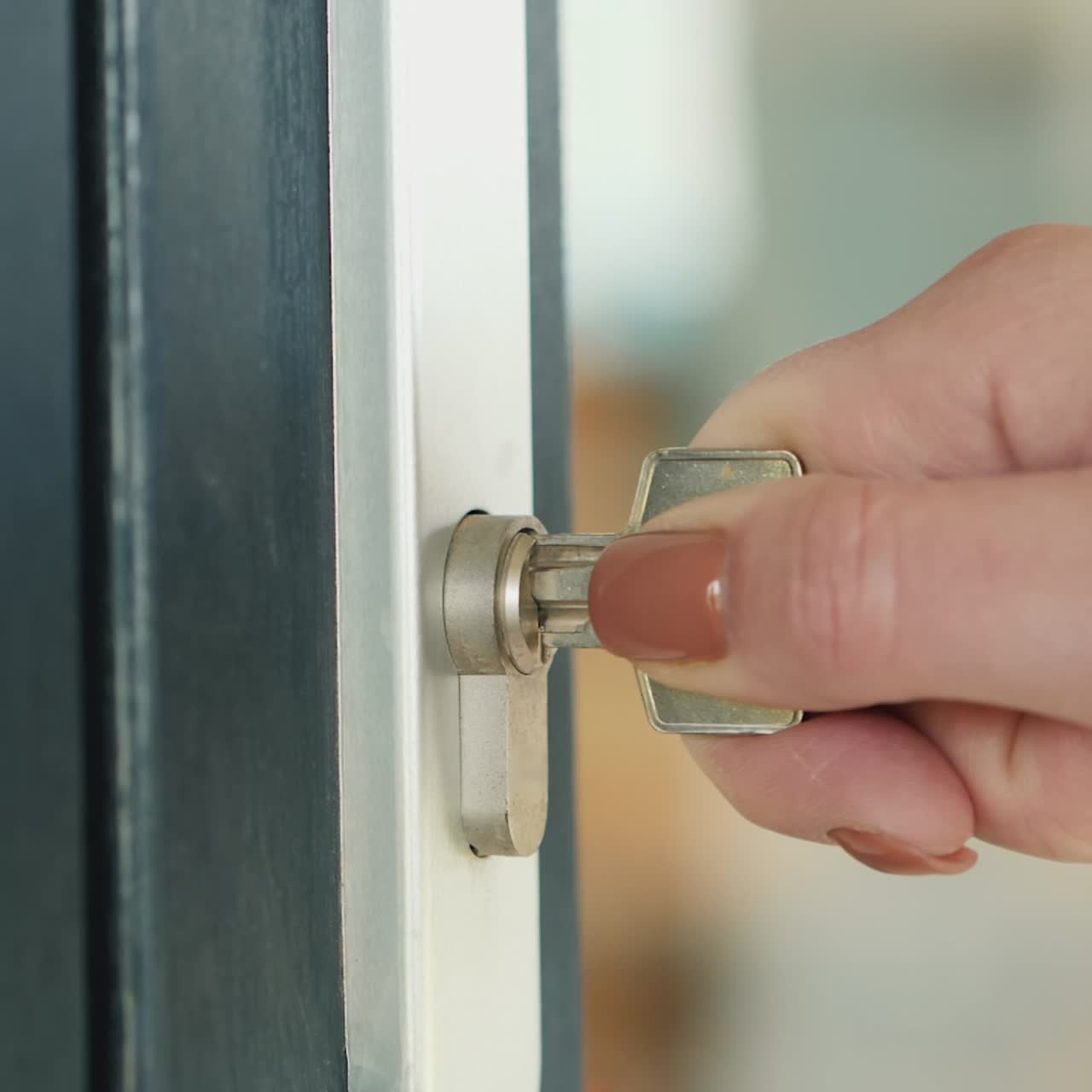 여자는 현관문 열쇠 구멍에 열쇠를 천천히 넣는다