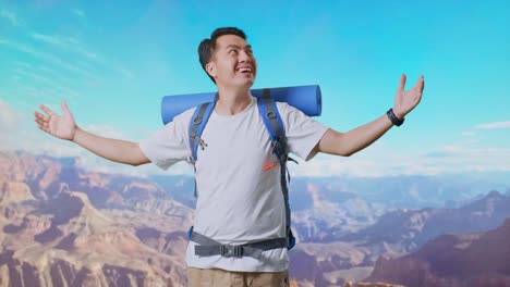 asian male hiker with mountaineering backpack smiling and spreading arms enjoy looking the view around while traveling at the top of mountain