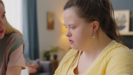 girl with down syndrome chatting with female friend