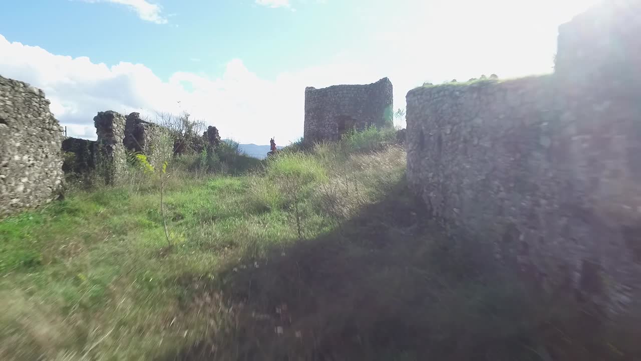 castillo en ruinas, vista del paisaje y músico tocando el bajo