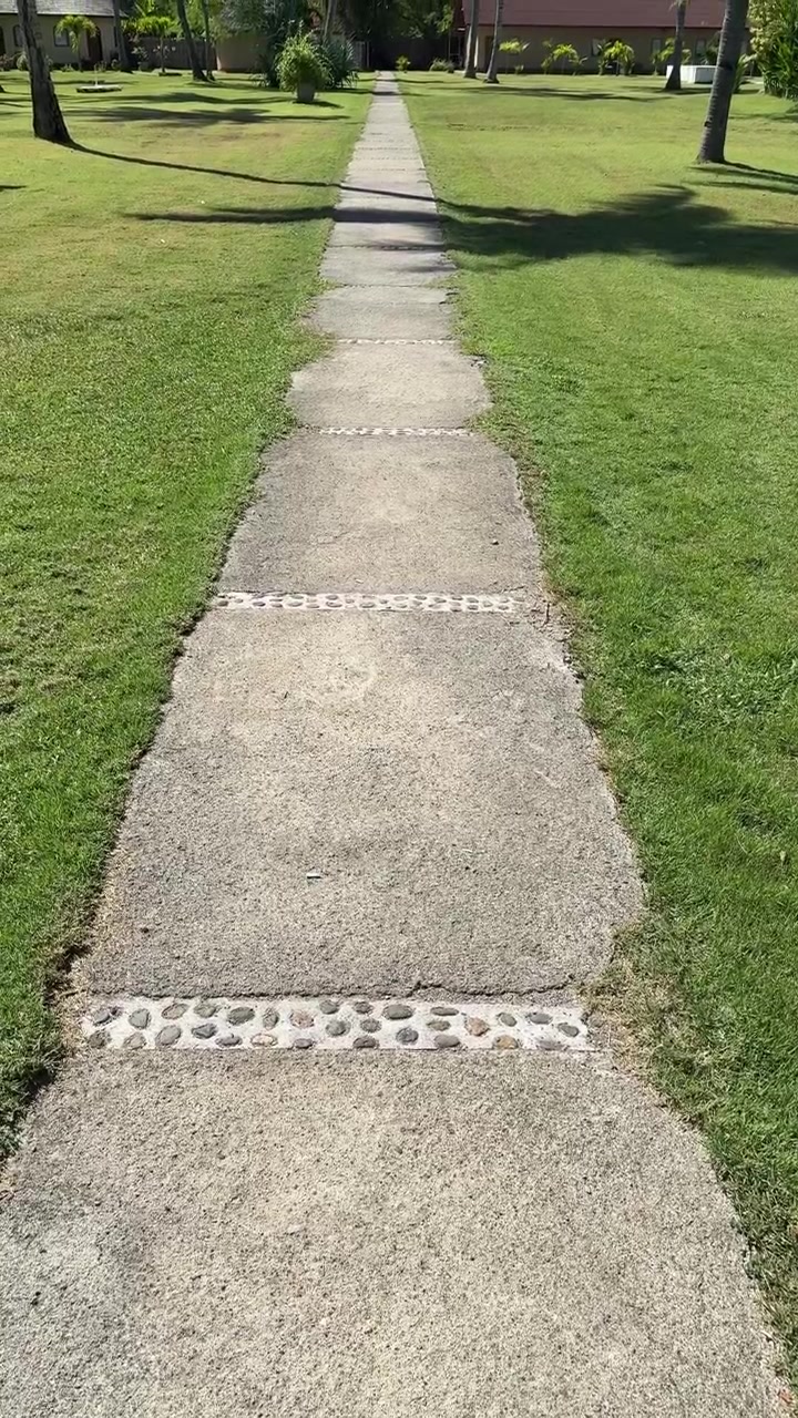 Long Concrete Path with Pebble Details in a Sunny Tropical Resort