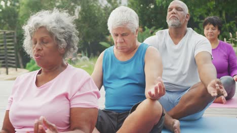 happy senior diverse people practicing yoga in garden at retirement home
